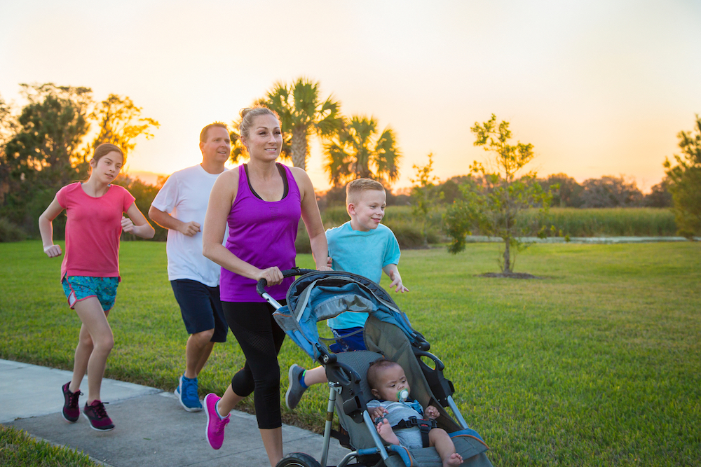 Family of joggers with a baby in a stroller